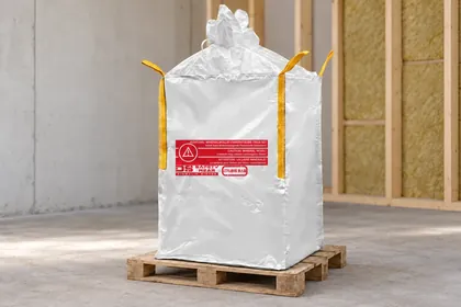 Big bag med rødt varseltrykk for mineralull på en pall (AI-redigert bilde)